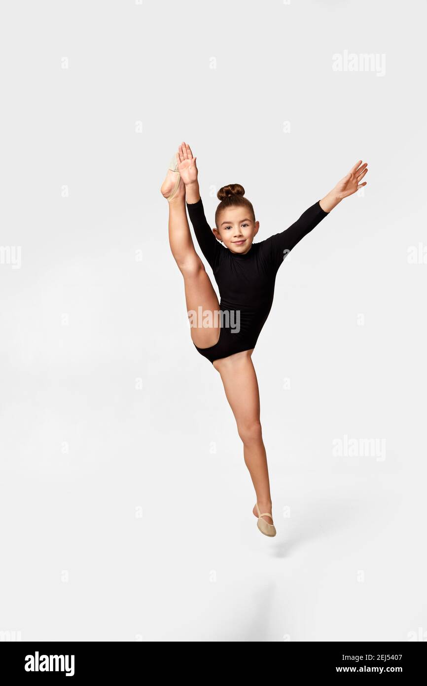 flexible little child girl in black sportswear perform transverse twine on  fly. Good stretching and gymnastics Stock Photo - Alamy