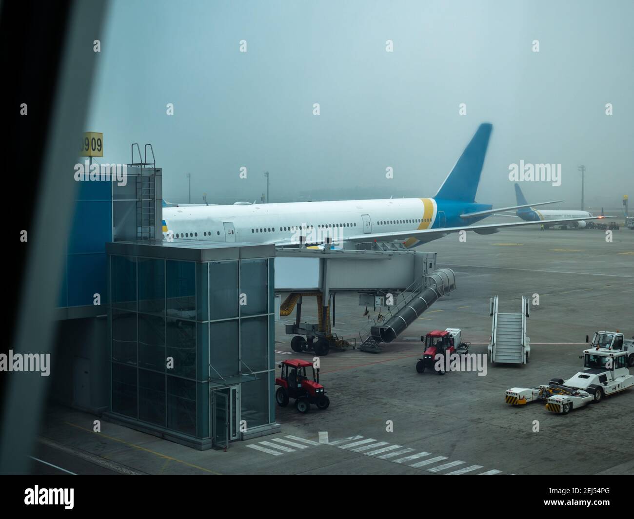 Jetway (telescopic air bridge) parked near the door of the airplane connecting it with the terminal gate in Boryspil International airport, Kyiv. Stock Photo