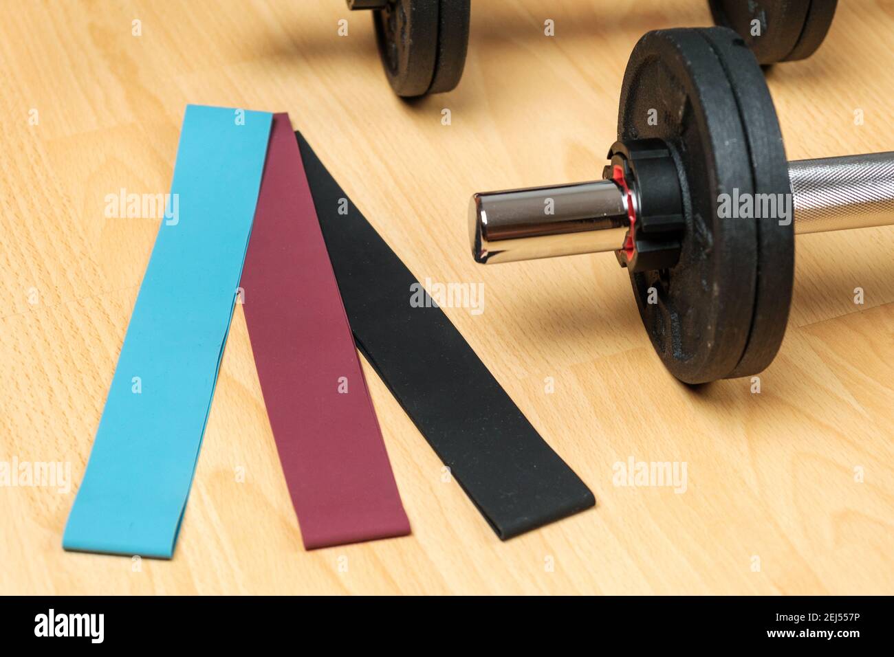 Dumbbells and elastic bands on the floor at home. Keeping fit during lockdown. Fitness equipment for strength training  Stock Photo