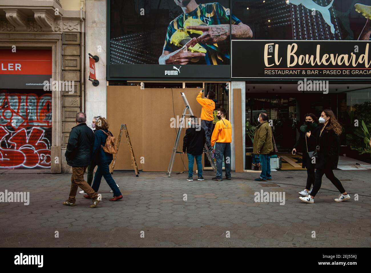 Barcelona, Spain. 21st Feb, 2021. Workers board up a shop after supporters  of imprisoned rap artist Pablo Hasel, convicted to jail for glorifying  terrorism and insulting Spain's former king in lyrics, have