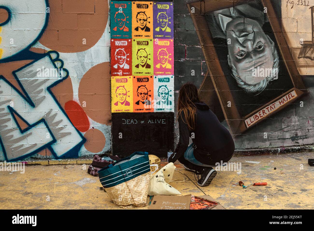 Barcelona, Spain. 21st Feb, 2021. A street artist paints graffiti criticizing Spain's monarchy in support of imprisoned rap artist Pablo Hasel. convicted to jail for glorifying terrorism and insulting Spain's former king in lyrics, after five nights of riots. Credit: Matthias Oesterle/Alamy Live News Stock Photo