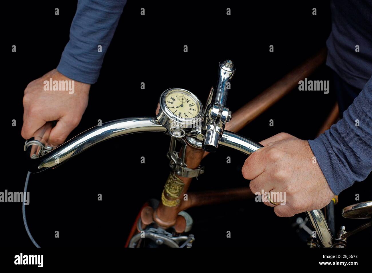 Rene a La Greve Tour De France 1920 fixed wheel bicycle out of gleaming copper.Hands of a man holding handlebars on vintage bicycle. Stock Photo
