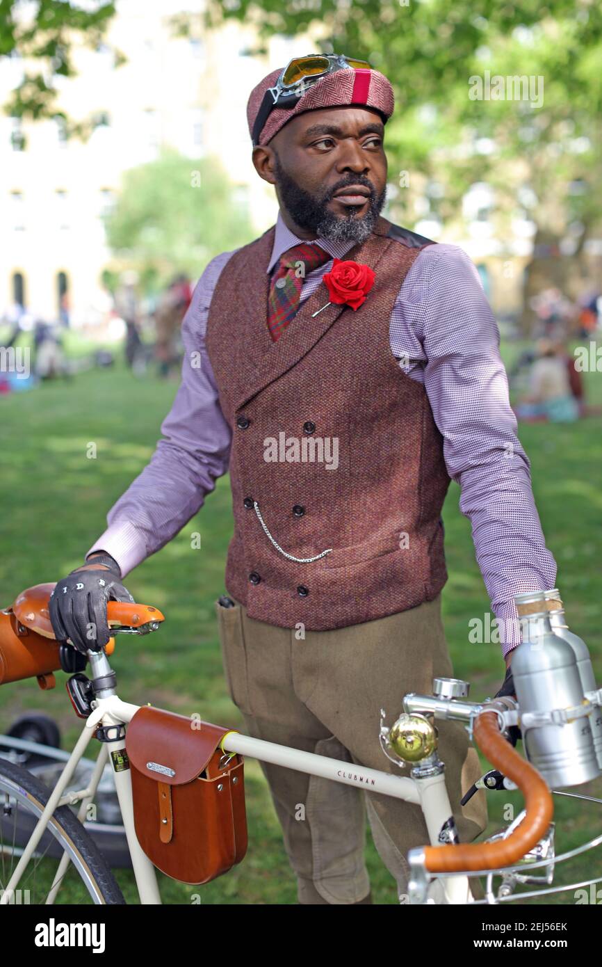 Close up of Man wearing red flower buttonhole standing beside bicycle at Tweed Run in London ,UK Stock Photo