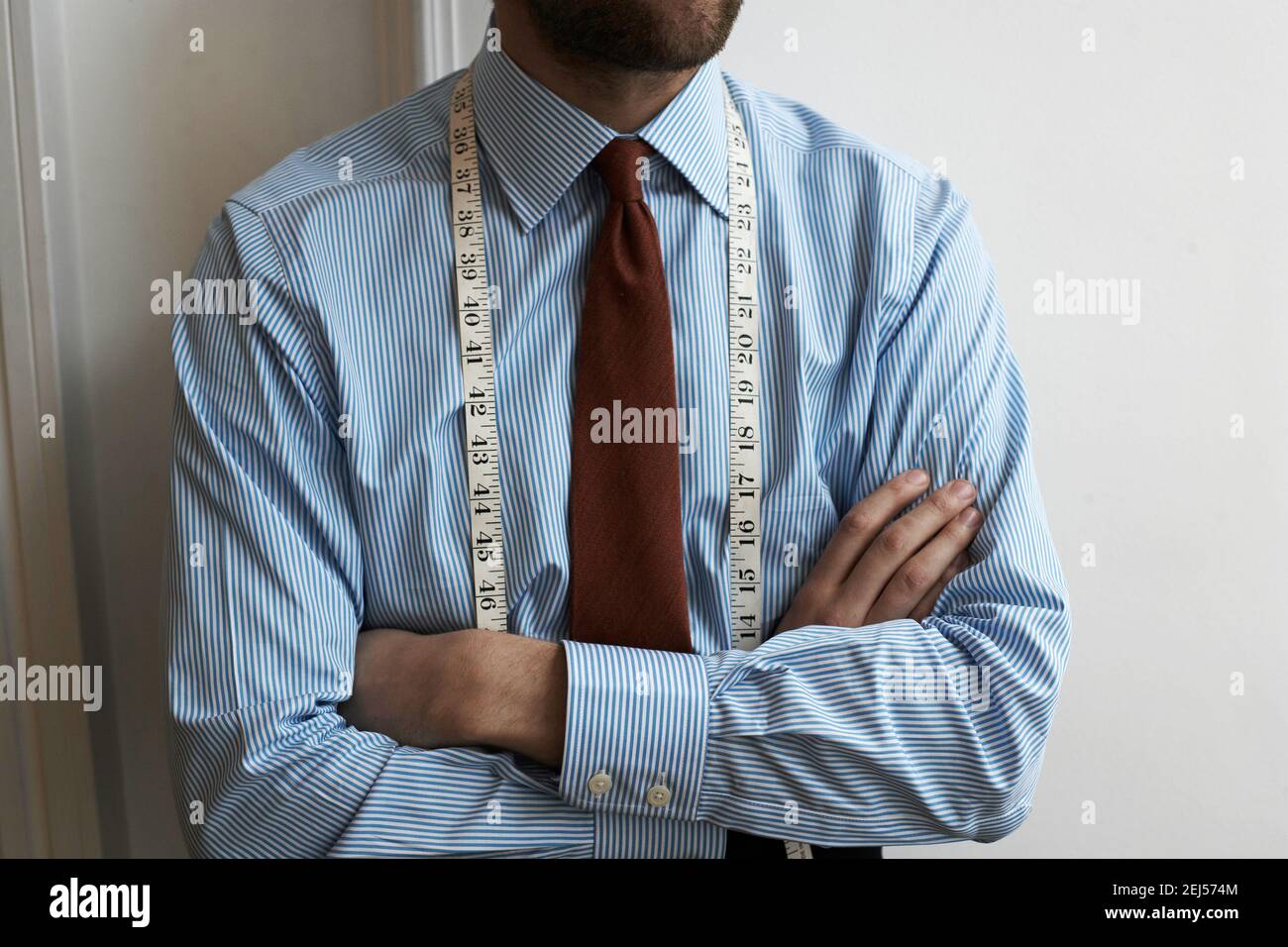cropped shot of tailor with a tape measure on his neck. Stock Photo