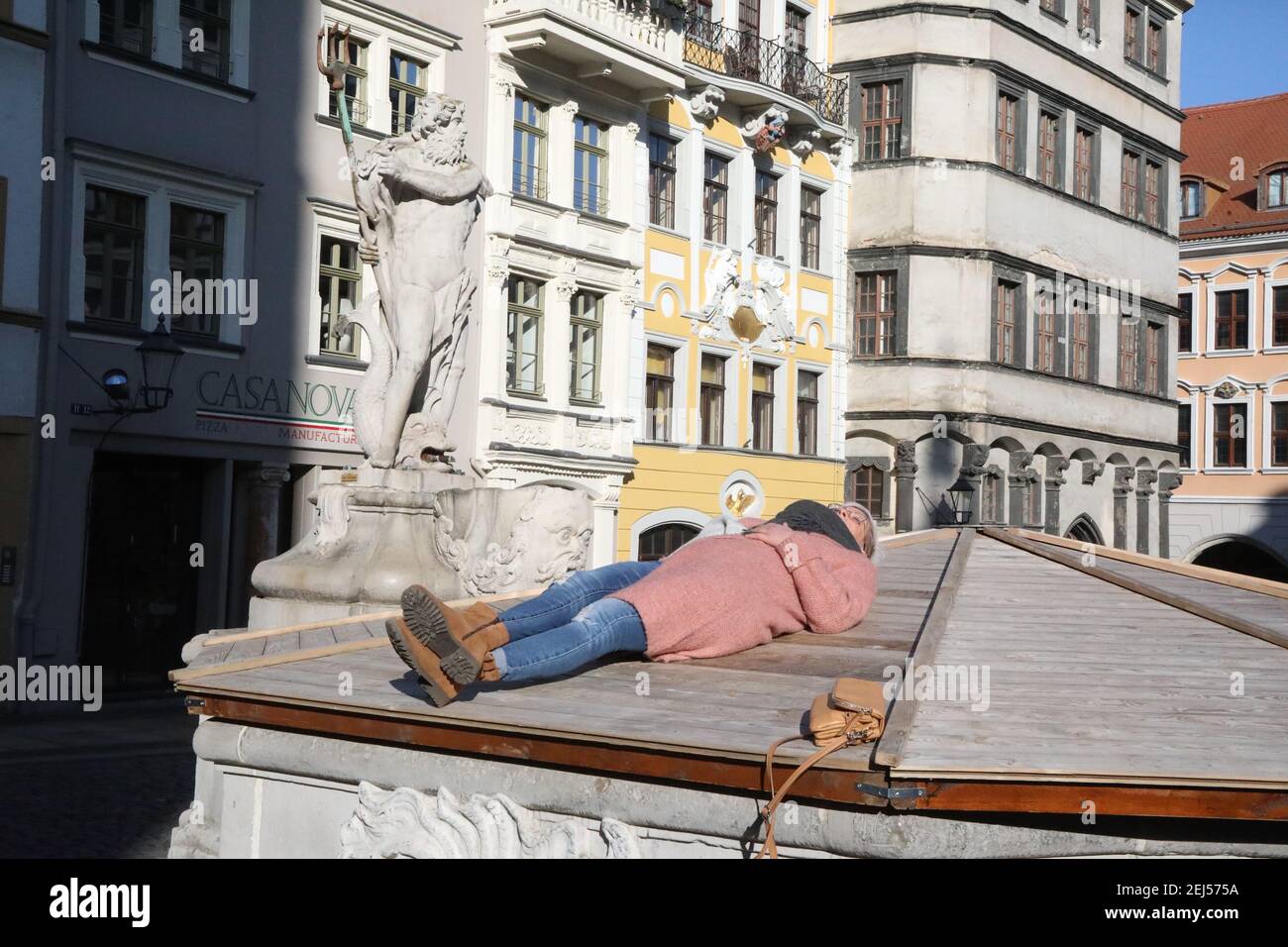 mangels Sitzgelegenheiten am Untermarkt , wusste diese sonnenhungrige Spaziergängerin sich zu helfen. Görlitz, 21.02.2021 Stock Photo
