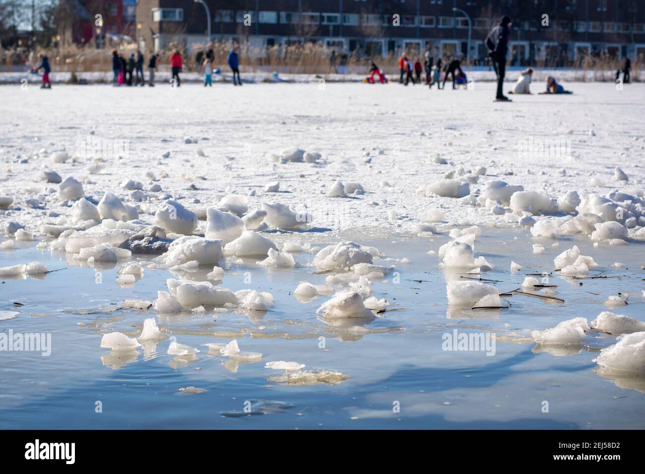 People skating on (thin) ice in the middle of a neighborhood. It is unsafe and fragile at the edge. Zwolle, The Netherlands Stock Photo