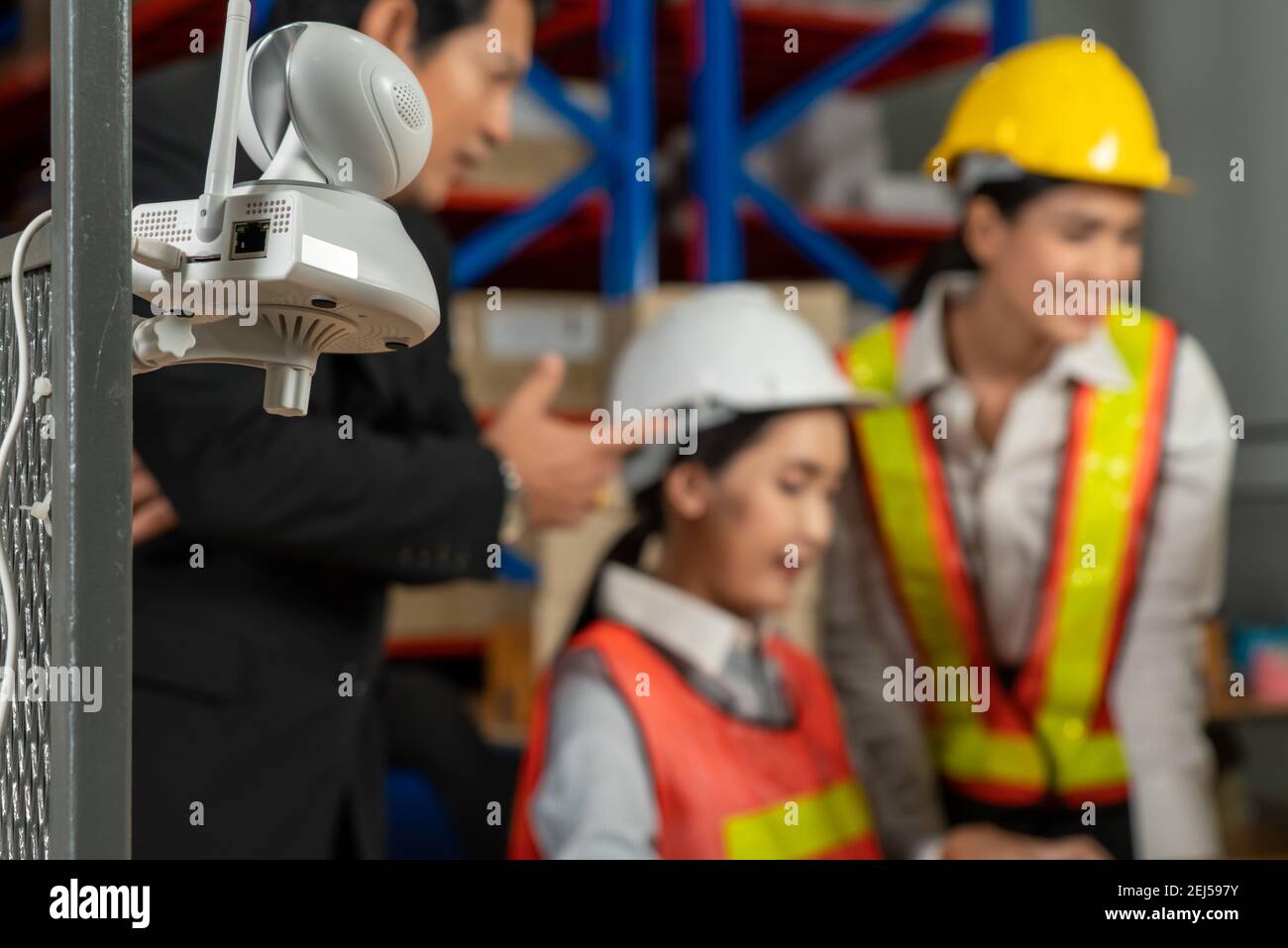 Security camera watching warehouse workers working in the storehouse