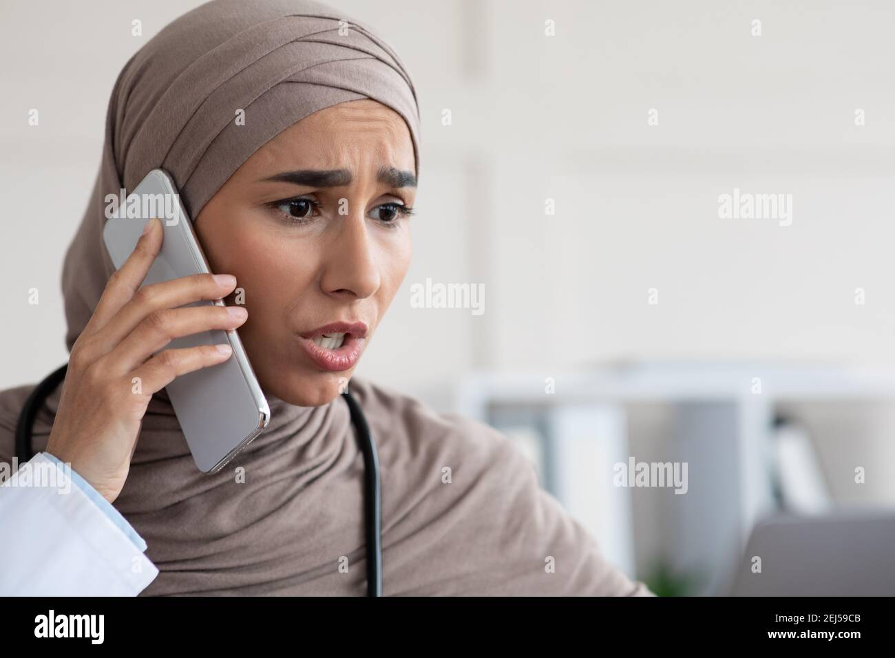 Closeup of angry doctor giving recommendation to patient on phone Stock Photo