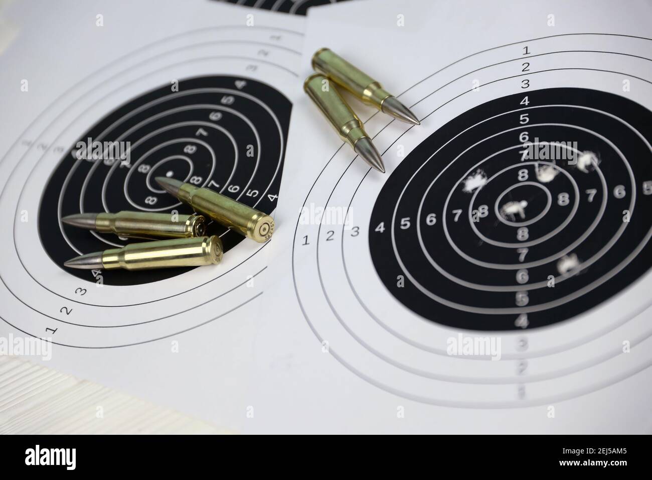 Many bullets with shooting targets on white table in shooting range polygon. Training for aiming