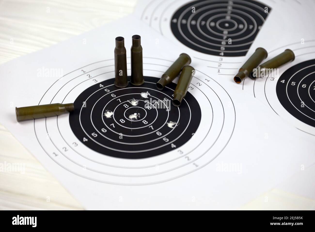 Many bullets with shooting targets on white table in shooting range  polygon. Training for aiming and shooting accuracy Stock Photo - Alamy