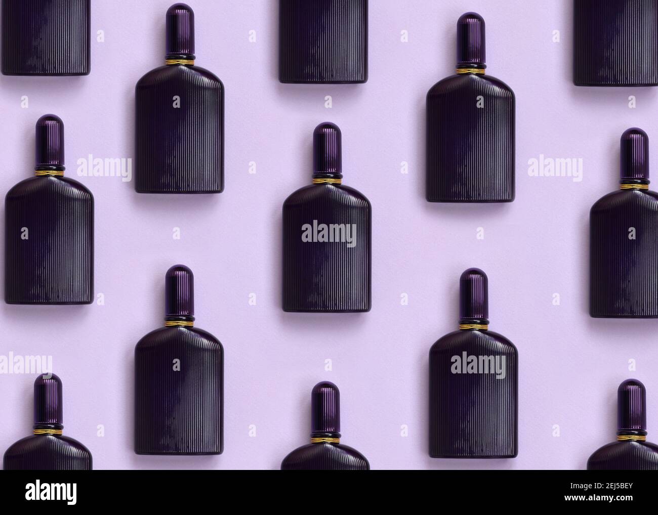 Dark purple perfume bottle with golden ribbon on pastel paper background.  Trendy fragrance design Stock Photo - Alamy