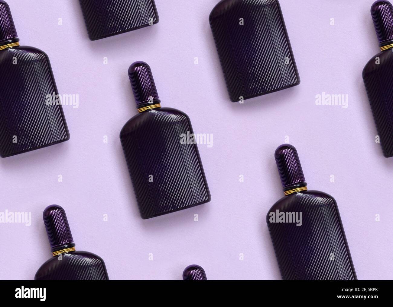 Dark purple perfume bottle with golden ribbon on pastel paper