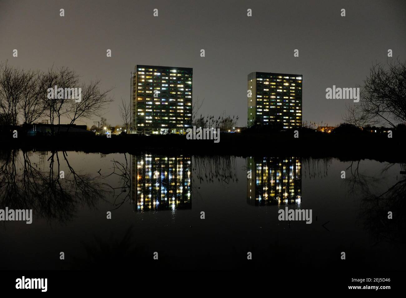 WANSTEAD FLATS, LONDON - 21ST FEBRUARY 2021: Fred Wigg and John Walsh towers at Harrow Road playing fields. Reflecting in water at night. Stock Photo