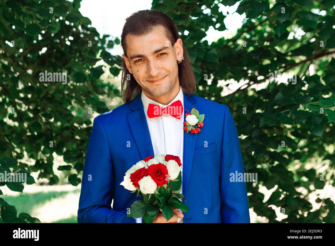 Portrait of young handsome man in blue suit with red bow tie. Wedding  concept Stock Photo - Alamy