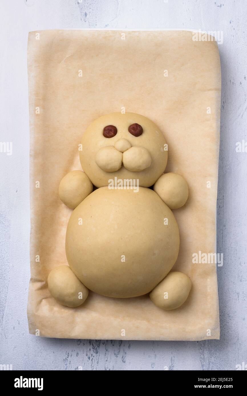 A process of making Easter Bunny Buns of delicious sweet dough. Do it yourself. Step by step instruction. Step 3. Make a muzzle of dough  - а cheeks a Stock Photo