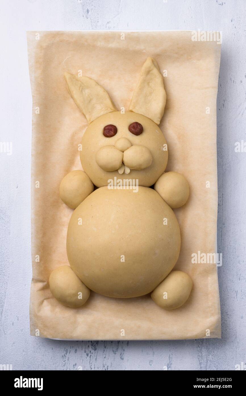 A process of making Easter Bunny Buns of delicious sweet dough. Do it yourself. Step by step instruction. Step 4. Make of almond petals a teeth and an Stock Photo