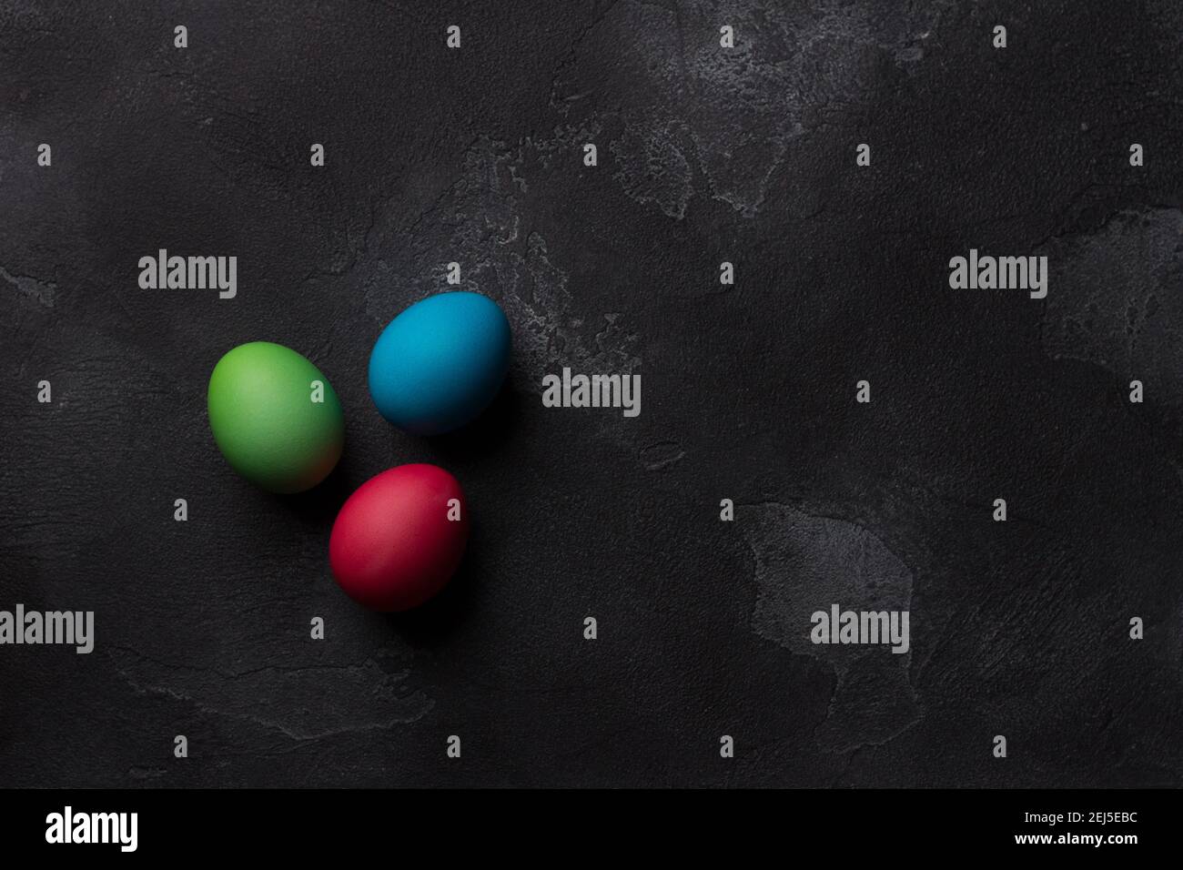 Easter eggs on black textured background, top view, space Stock Photo