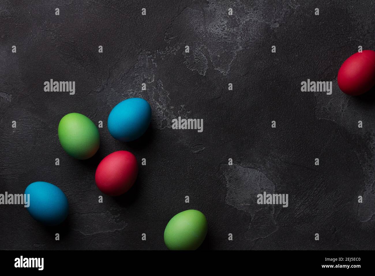 Easter eggs on black textured background, top view, space Stock Photo