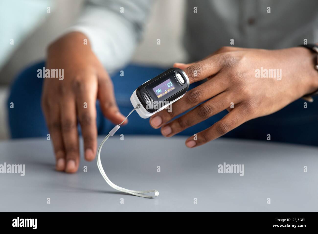 Unrecognizable African Man Using Pulse Oximeter Checking Oxygen Saturation Indoor Stock Photo