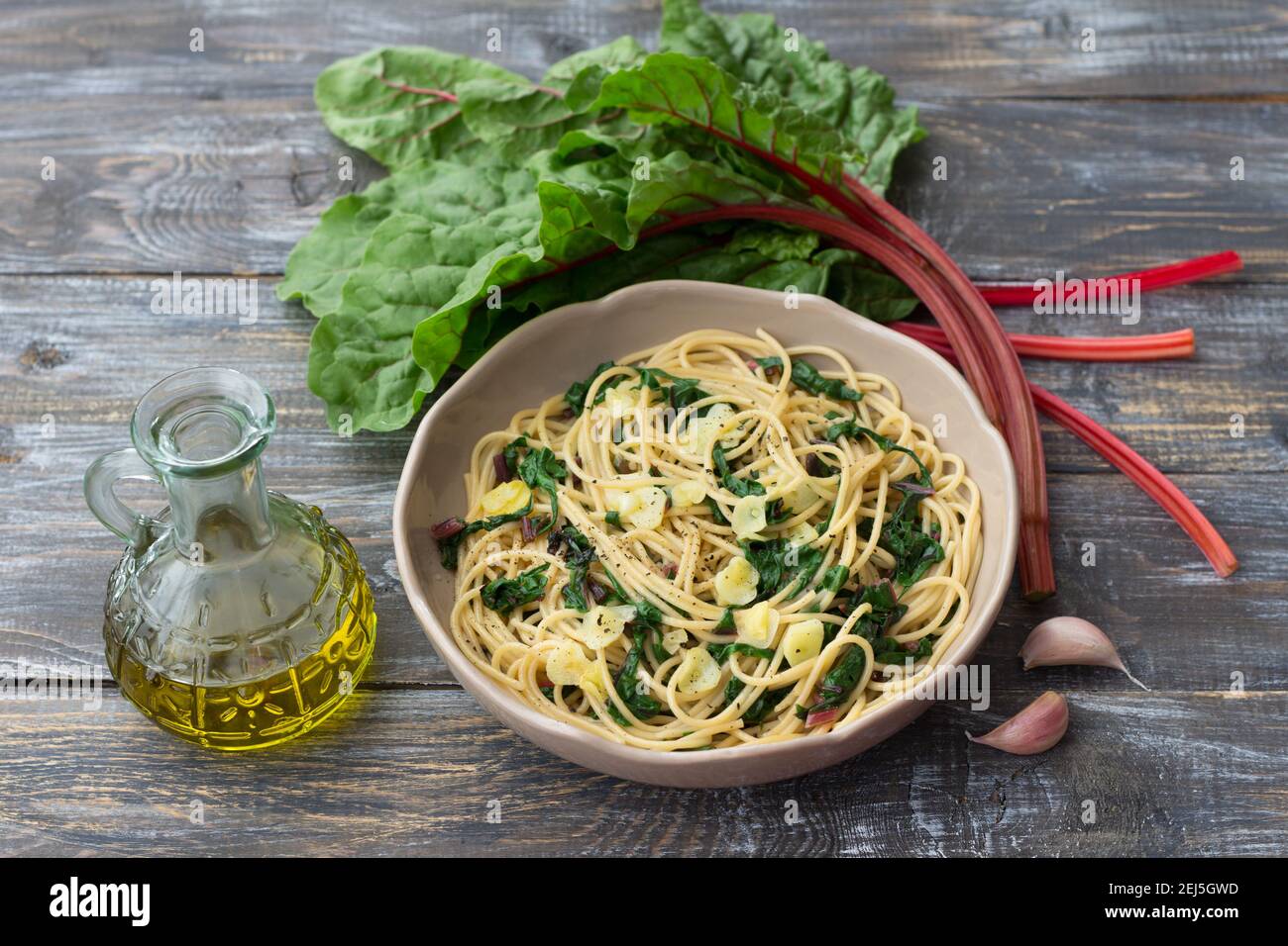 Vegan spaghetti with chard and garlic on a wooden table. Delicious homemade food Stock Photo