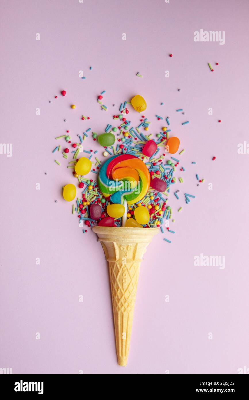 Overhead view of ice cream cone with lollipop, jelly beans and