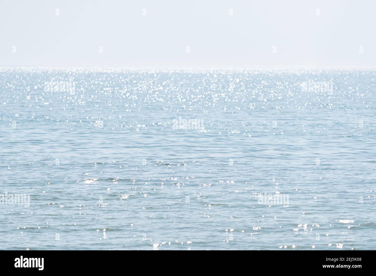 Abstract minimalistic natural background with blue sea water, highlights and ripples Stock Photo