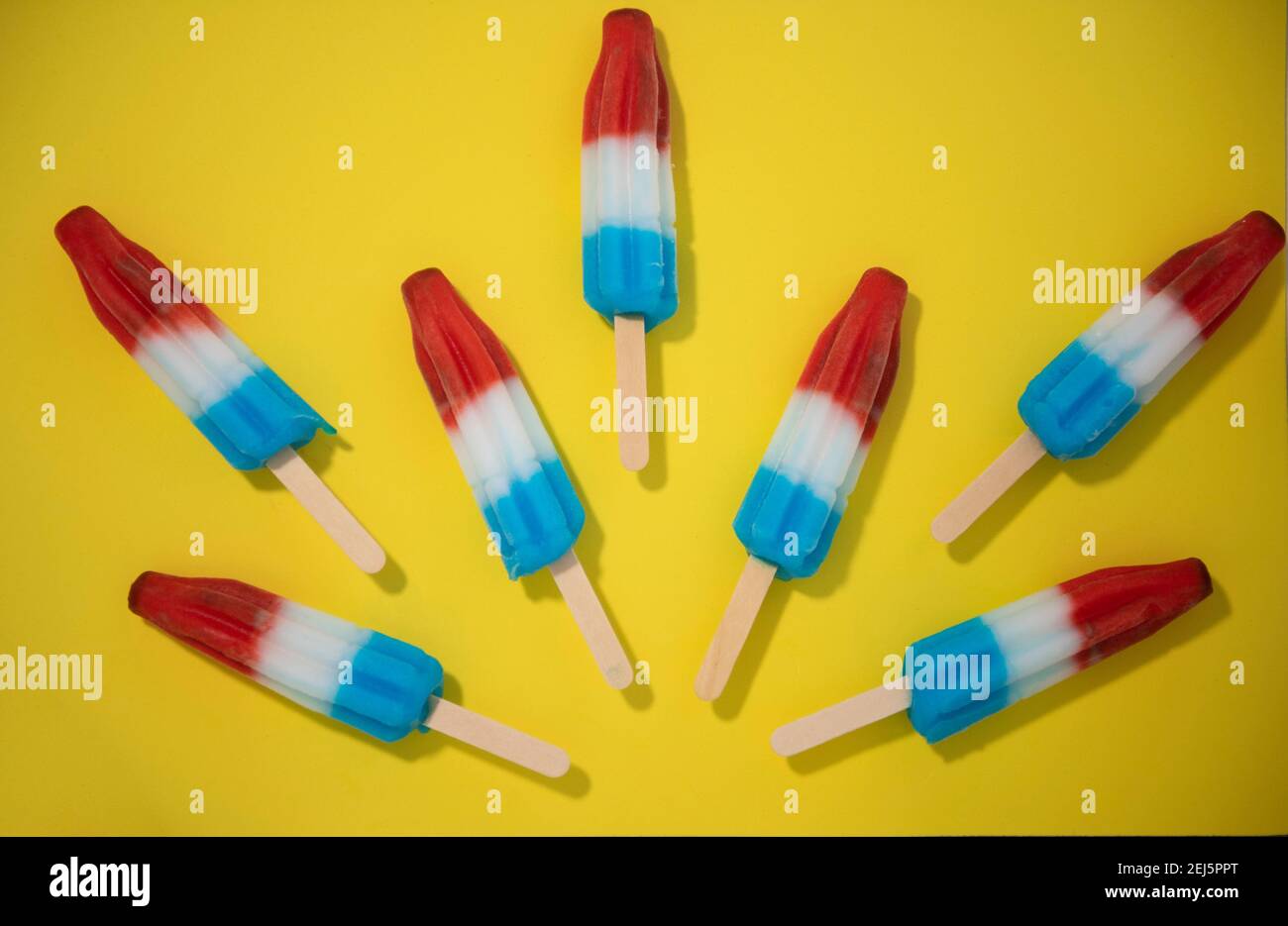 Red, White and Blue Novelty ice cream bombpop shot on yellow background, stop action animation exploding like fireworks. Series 7 of 8. Stock Photo