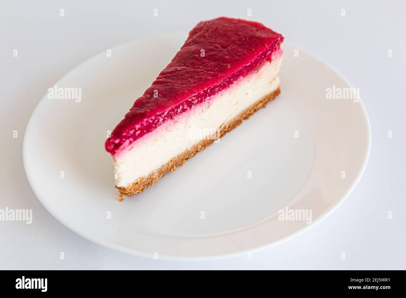 Close up of Cheesecake slice on white plate. Raspberry cheesecake. Copy space. selective focus Stock Photo