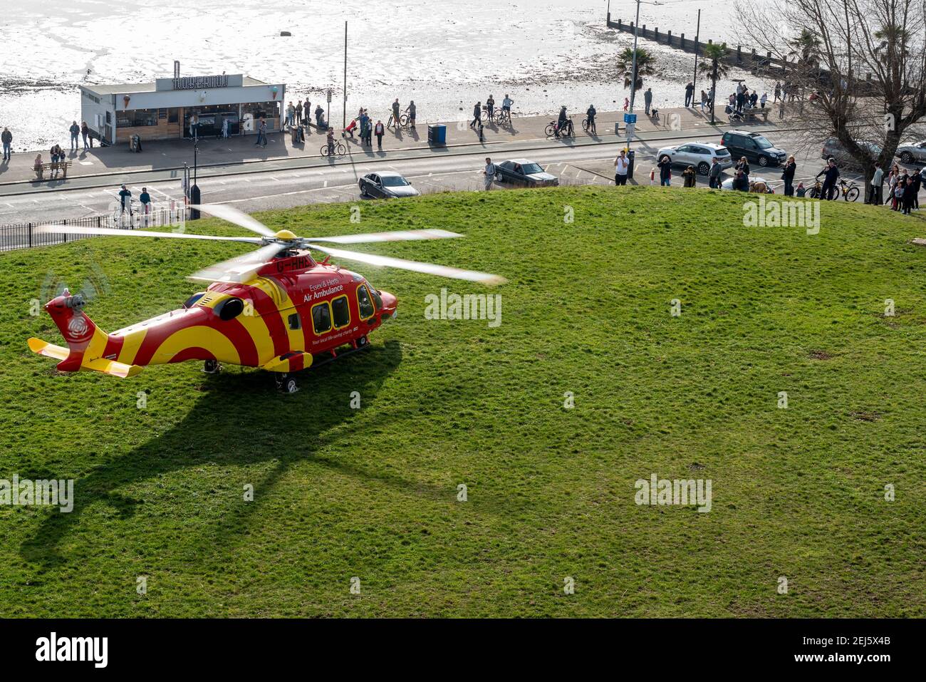 Essex & Herts Air Ambulance landed on cliffs in Southend on Sea, Essex, UK, on a bright sunny winter day, during COVID 19 lockdown. People on seafront Stock Photo