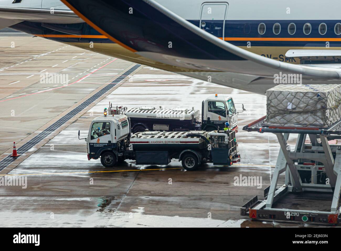 Lavatory service vehicles for emptying and refilling lavatories onboard aircraft of a Singapore Airlines machine at apron of Changi Intern. Airport Stock Photo