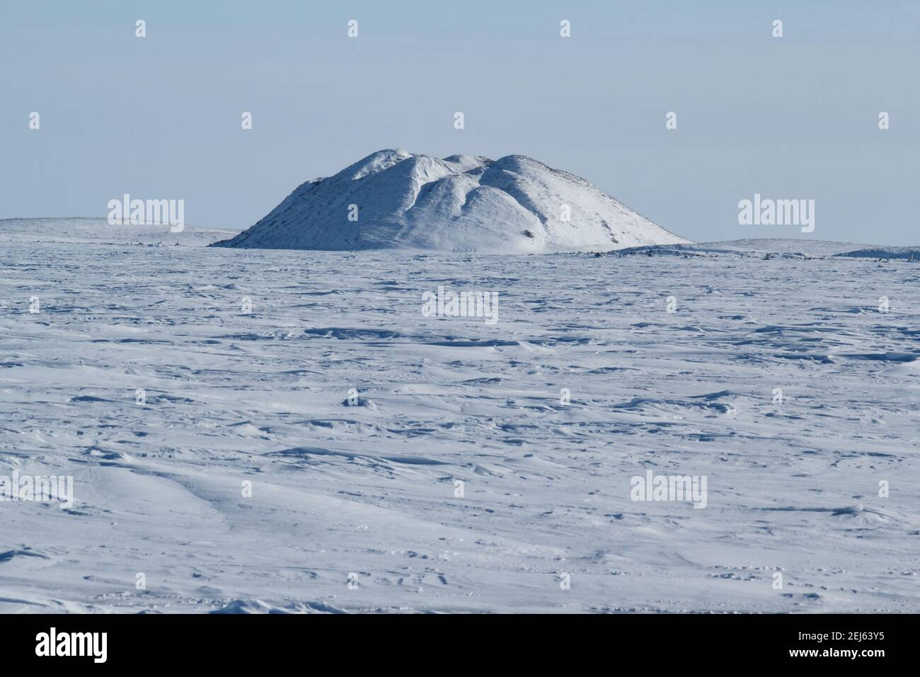 A pingo landmark (intra-permafrost ice-cored hill) in winter on the frozen arctic landscape near Tuktoyaktuk, Northwest Territories, Canada Stock Photo