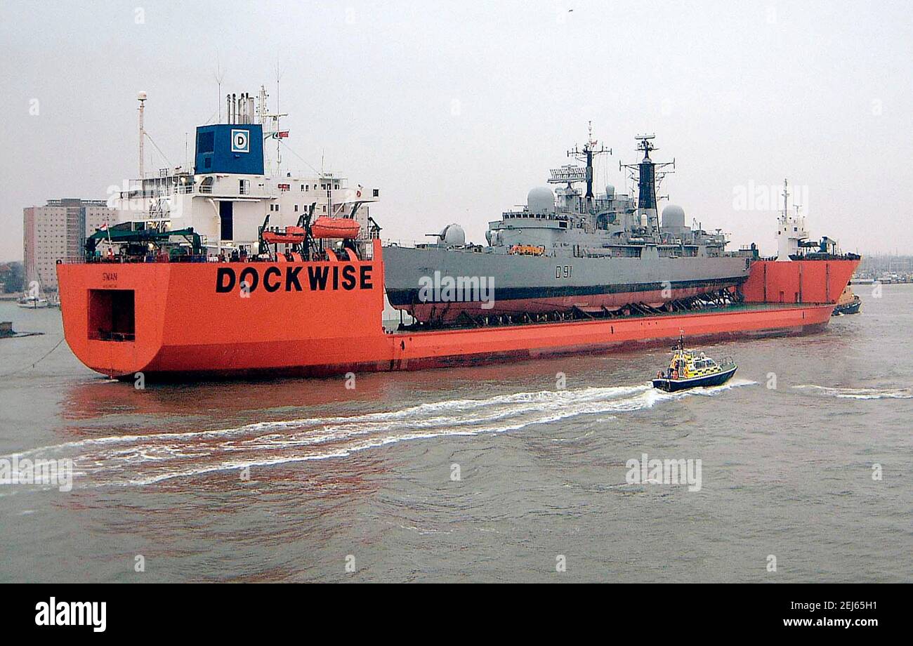 AJAXNETPHOTO. 08 DEC 2002. PORTSMOUTH.ENGLAND. - PIGGY BACK LIFT - THE SEMI-SUBMERSIBLE SHIP SWAN ENTERS PORTSMOUTH HARBOUR TODAY LOADED WITH THE ROYAL NAVY'S DESTROYER NOTTINGHAM WHICH RAN AGROUND ON ROCKS OFF HOWE ISLAND IN THE PACIFIC EARLIER THIS YEAR.  PHOTO:JONATHAN EASTLAND/AJAX.  REF: (D)SWAN20812 1 Stock Photo