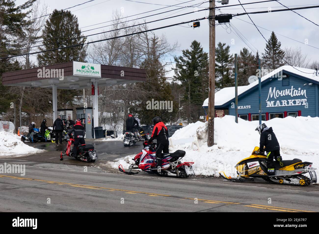 A group of snowmobiles lining up at the gas pumps at Mountain Market in Speculator, NY in the Adirondack Mountains Stock Photo
