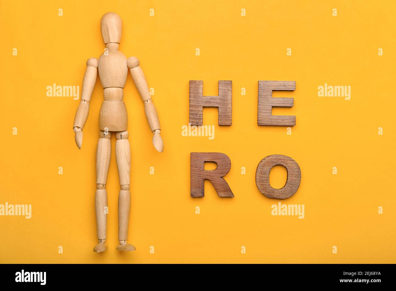 Wooden mannequin with word HERO on color background Stock Photo Alamy