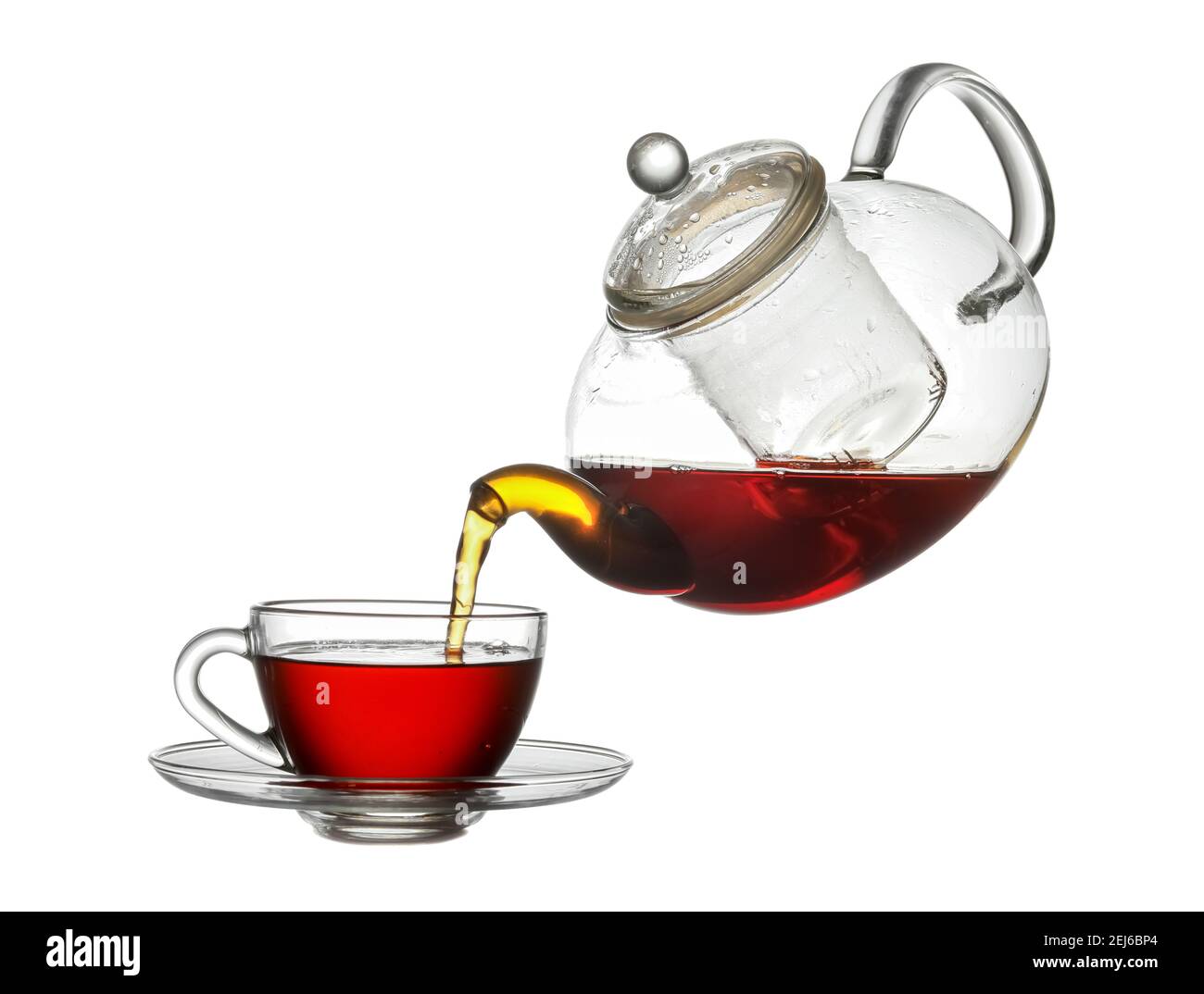 Pouring of hot tea from teapot into cup on white background Stock Photo Alamy