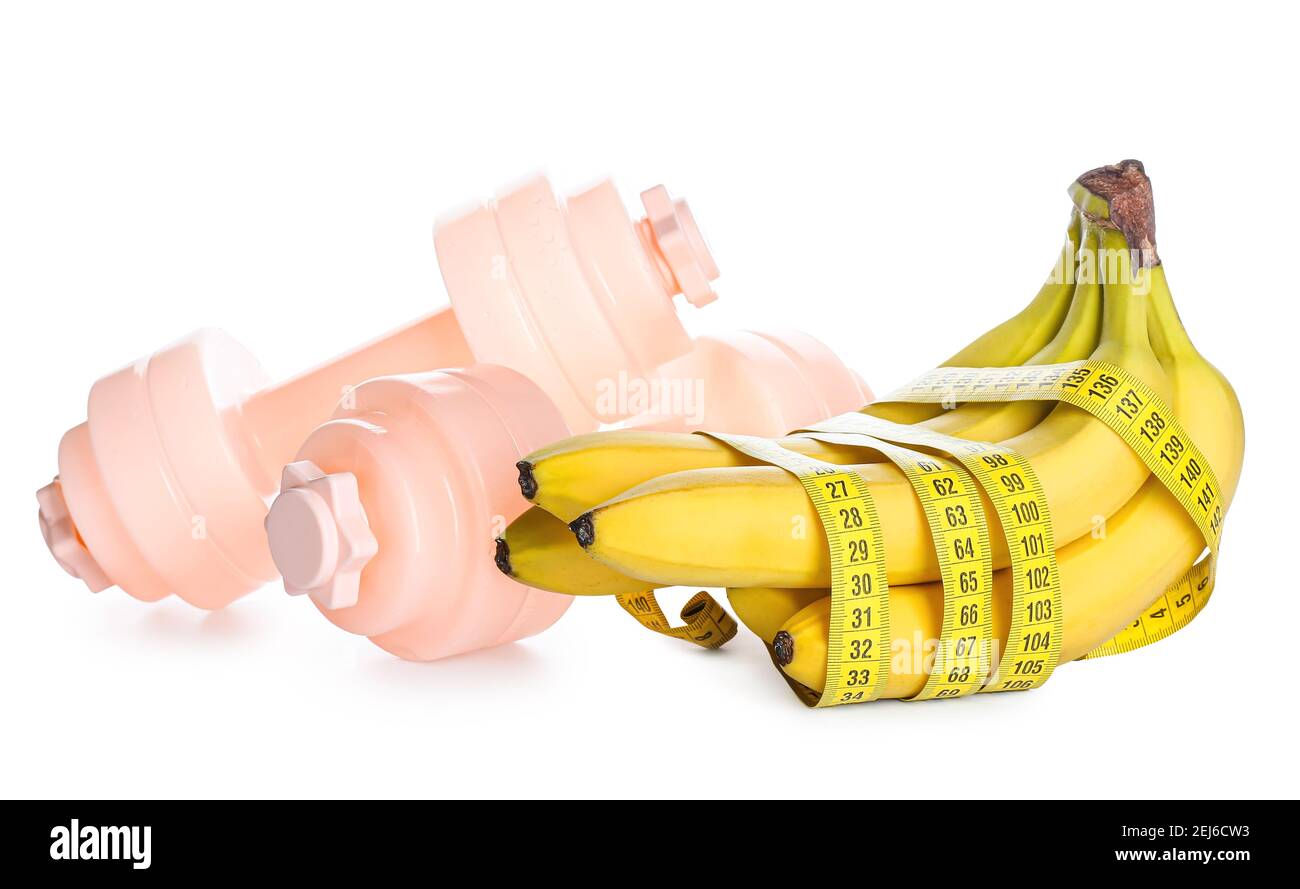 Ripe bananas and dumbbells on white background. Weight loss concept