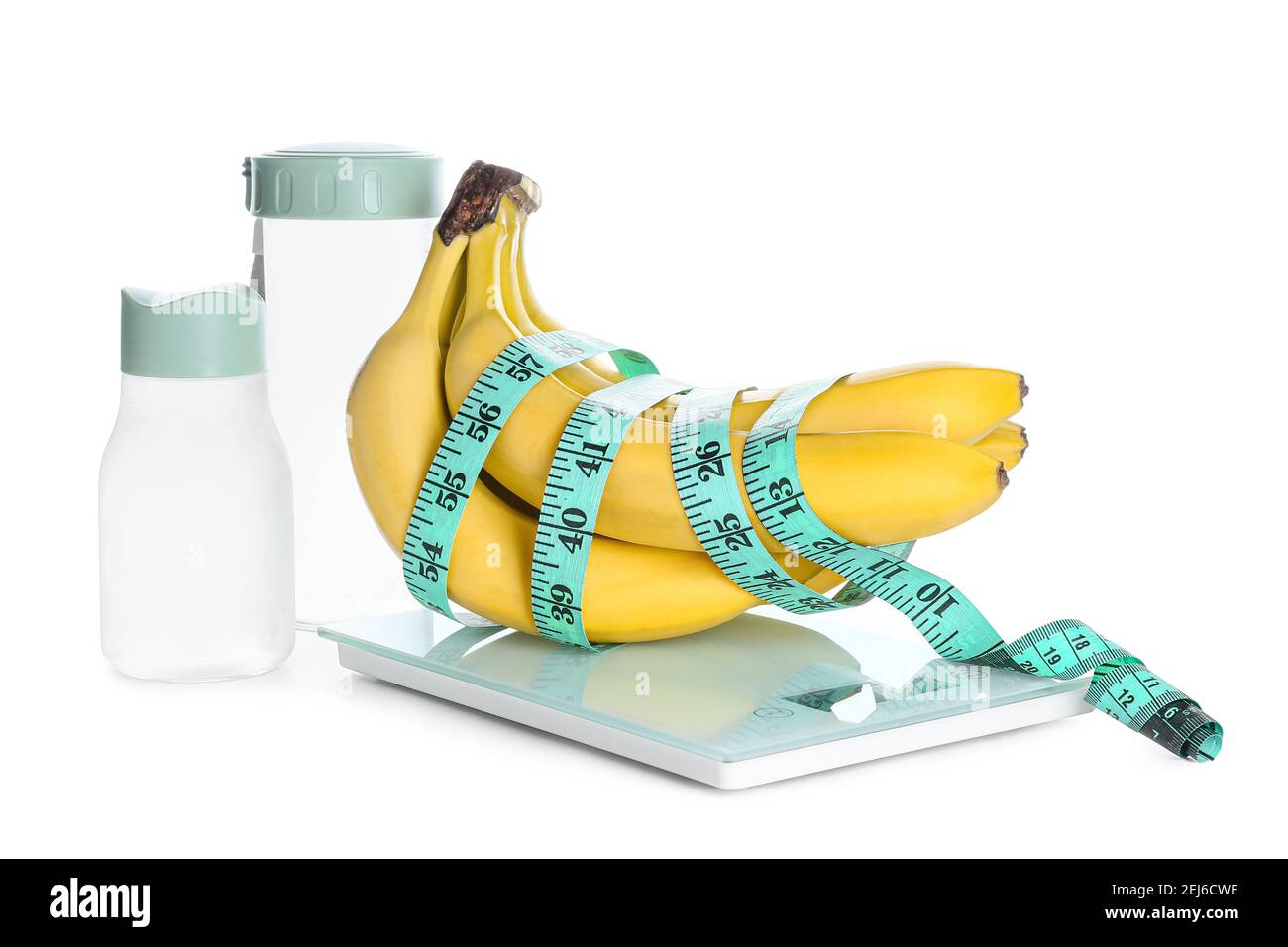 Ripe bananas, bottles of water and scales on white background. Weight