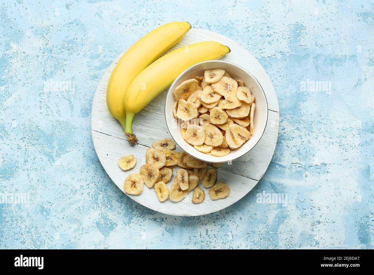 Fresh bananas and crispy chips on color background Stock Photo Alamy