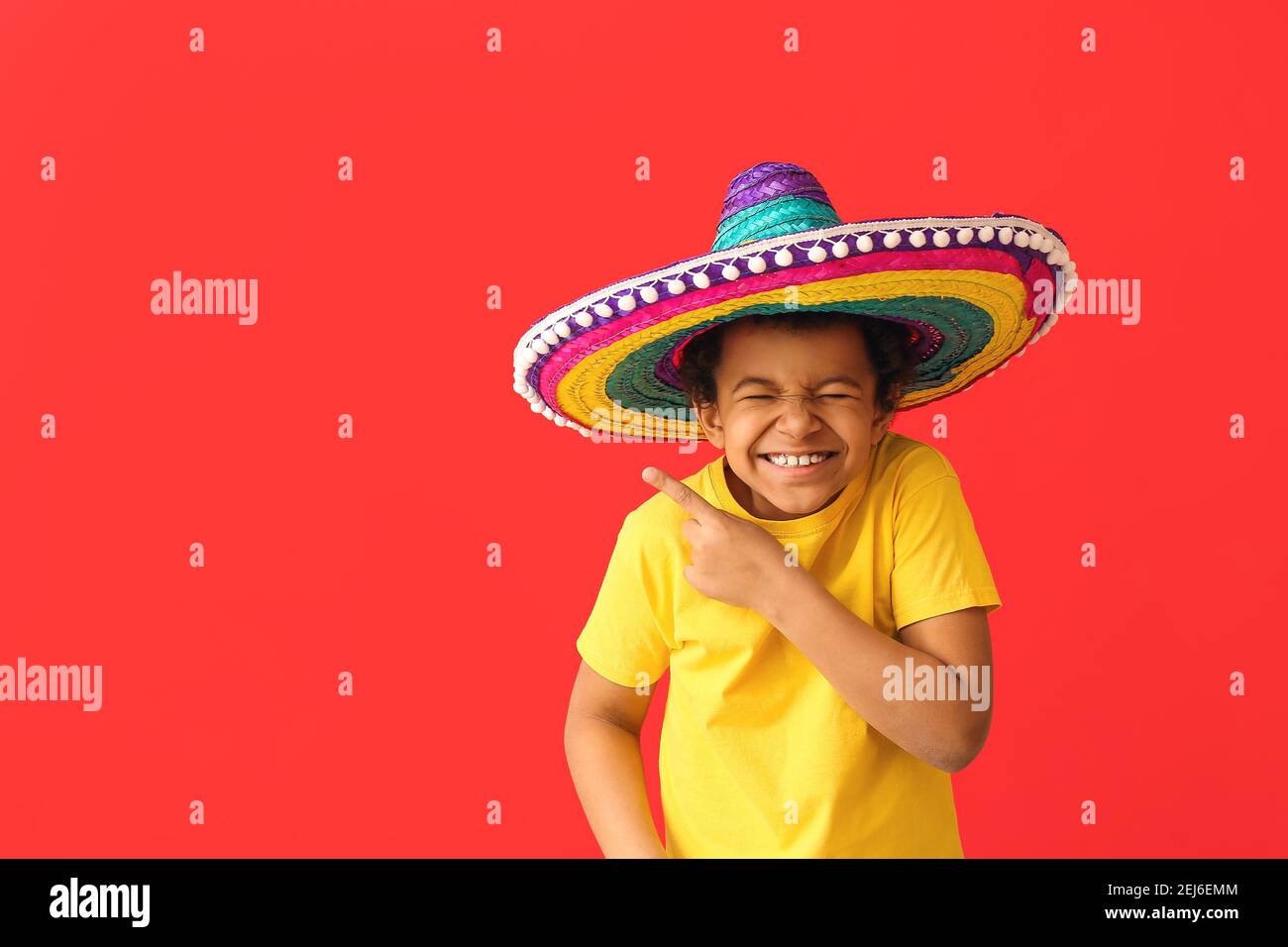 Funny Mexican boy in sombrero hat showing something on color background  Stock Photo - Alamy