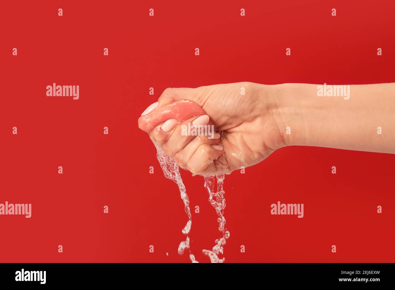 Hand squeezing wet makeup sponge on color background Stock Photo Alamy