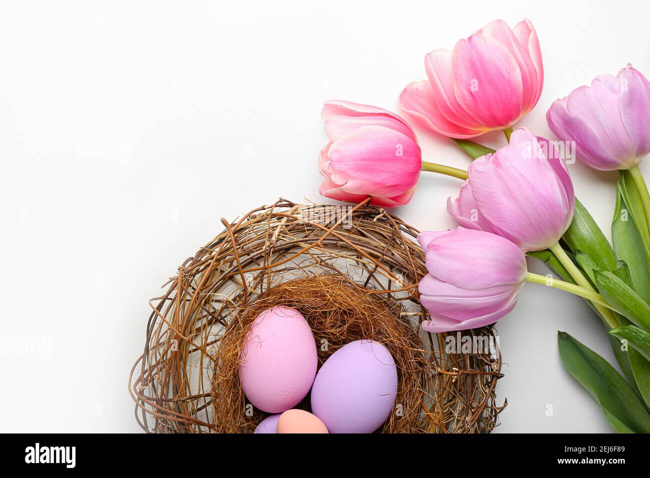 Beautiful Easter composition with eggs and spring flowers on white background Stock Photo