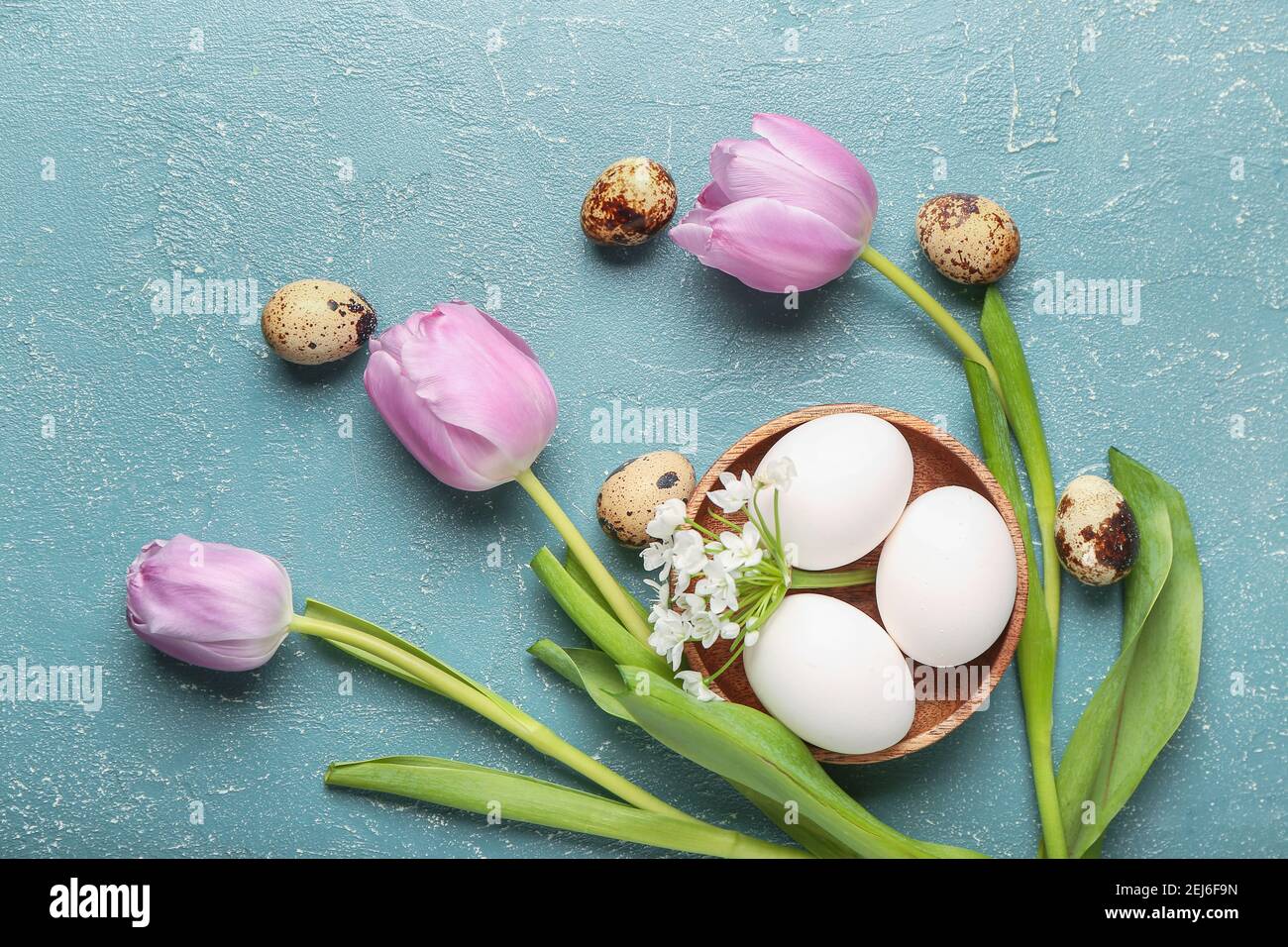 Composition with Easter eggs and spring flowers on color background ...