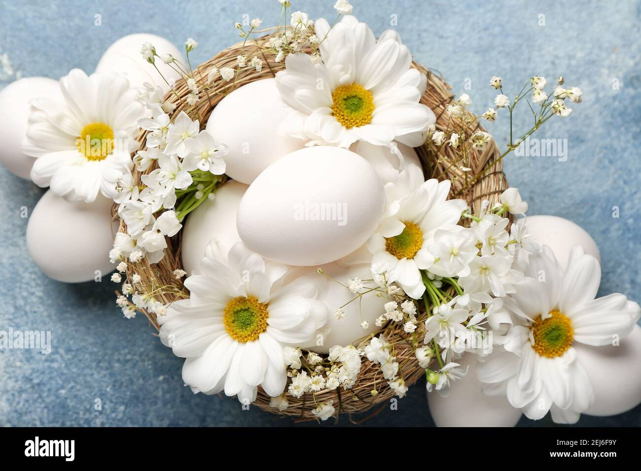 Composition with Easter eggs and spring flowers on color background ...