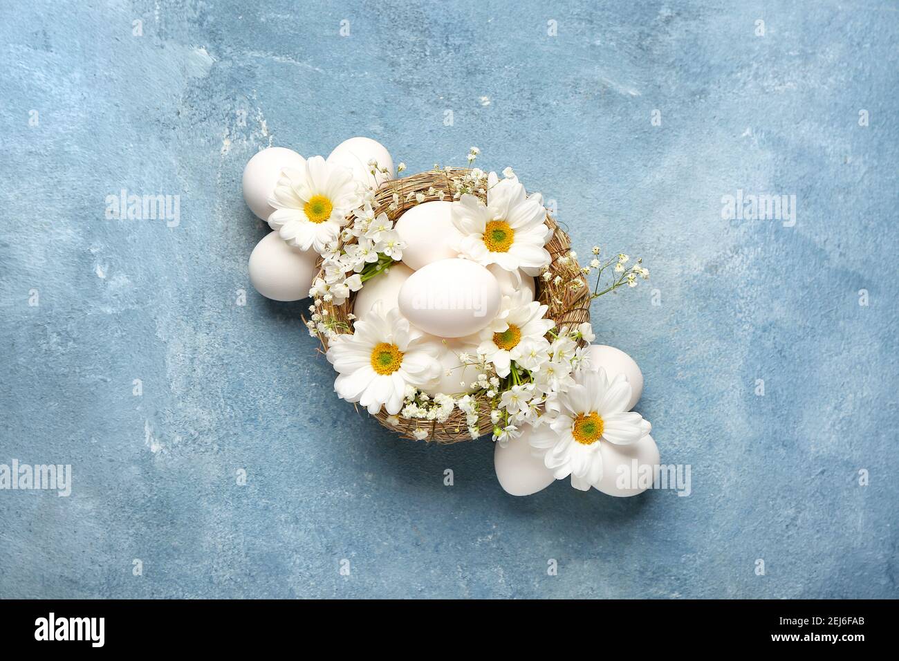 Composition with Easter eggs and spring flowers on color background ...