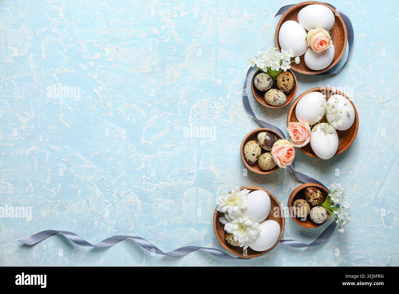 Composition with Easter eggs and spring flowers on color background ...