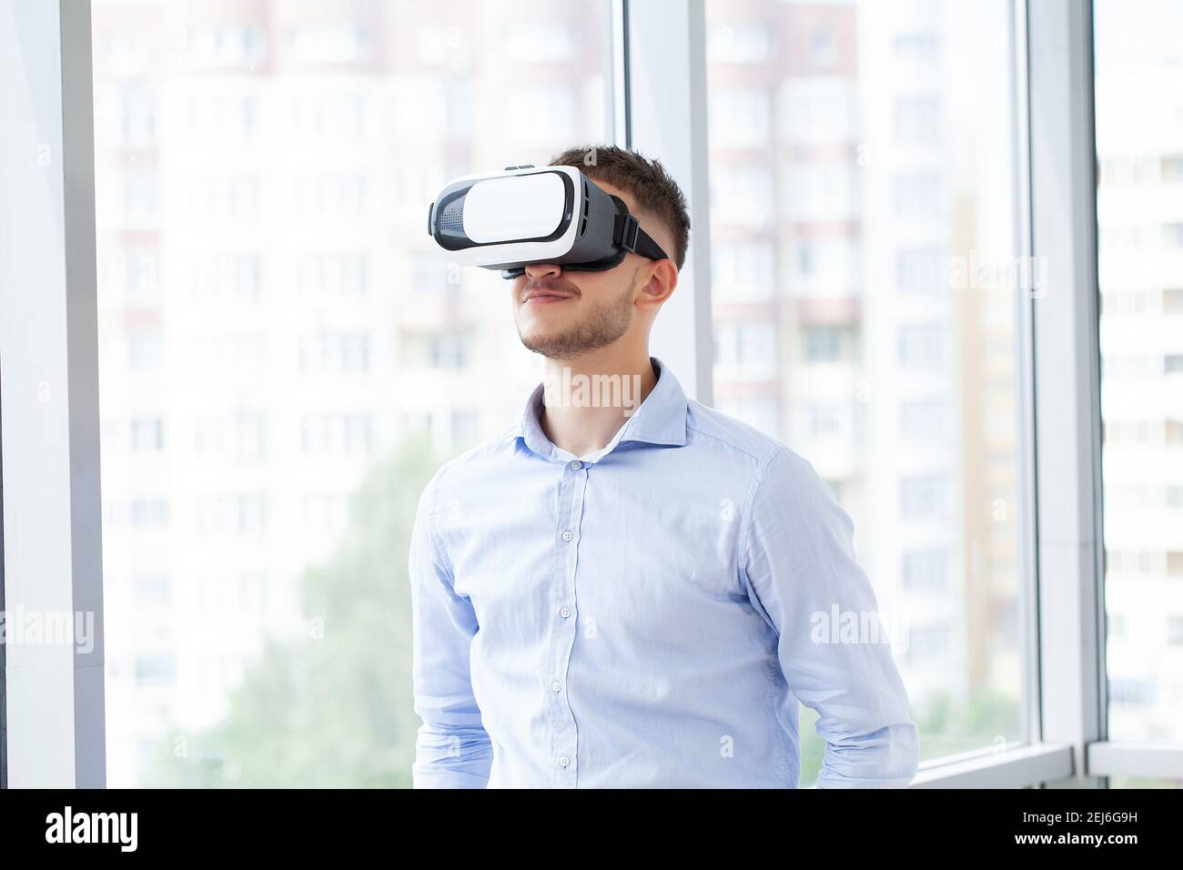 Young man wearing virtual reality goggles in modern coworking studio ...