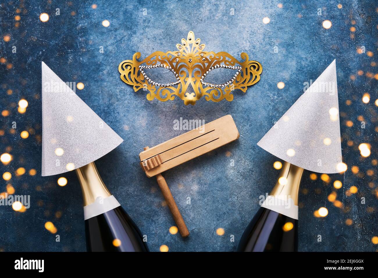 Jewish holiday Purim celebration background with party hats, mask and champagne on blue background. Top view Stock Photo