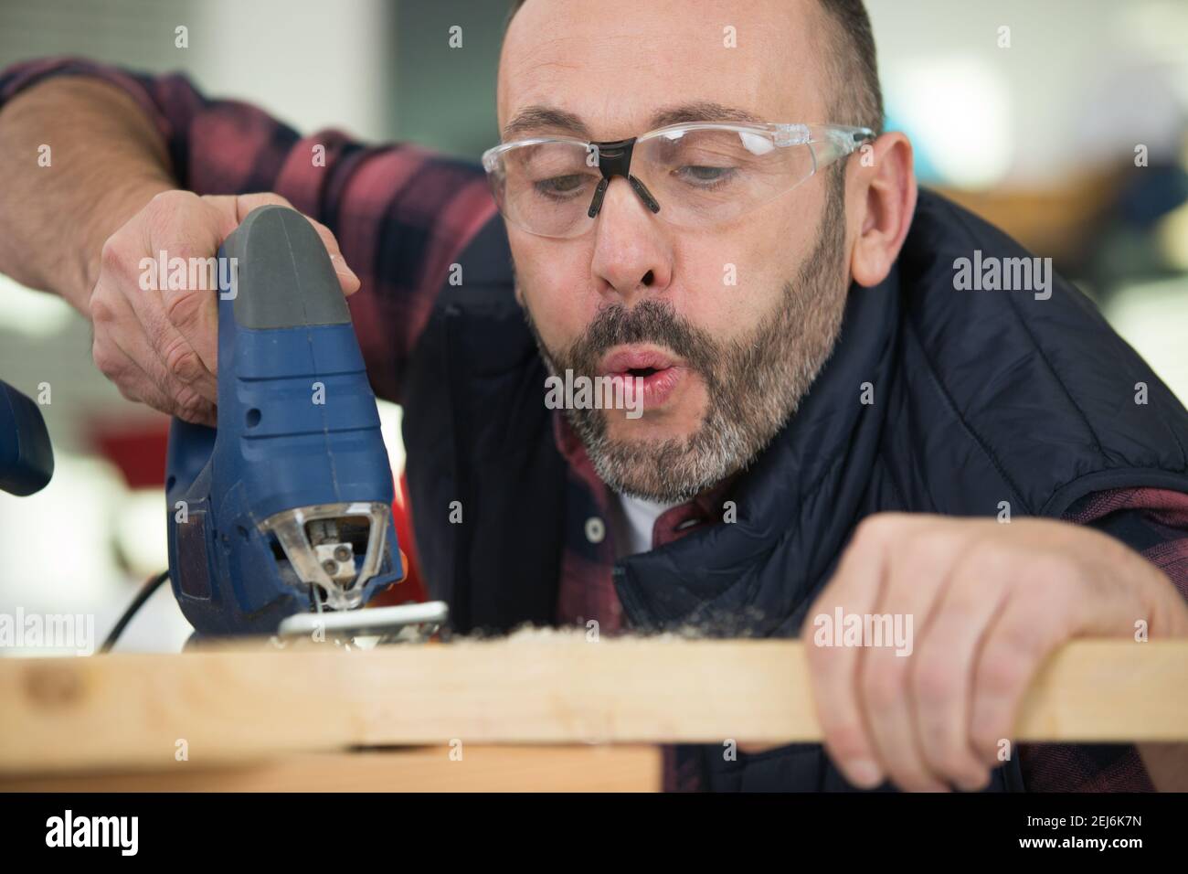 Mature carpenter blowing dust hi-res stock photography and images - Alamy