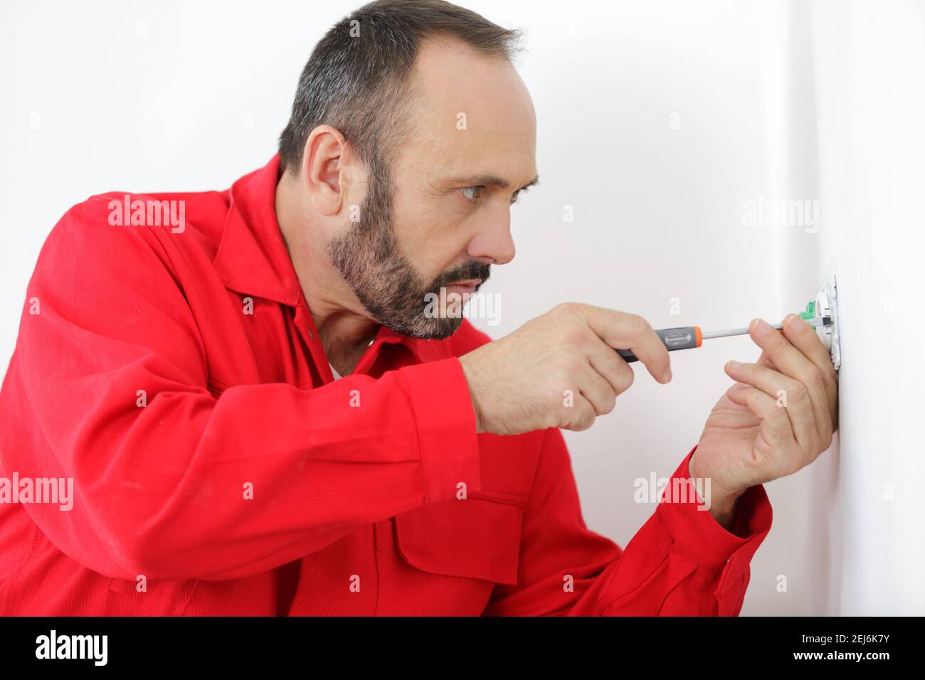 electrician using screwdriver on plug socket Stock Photo