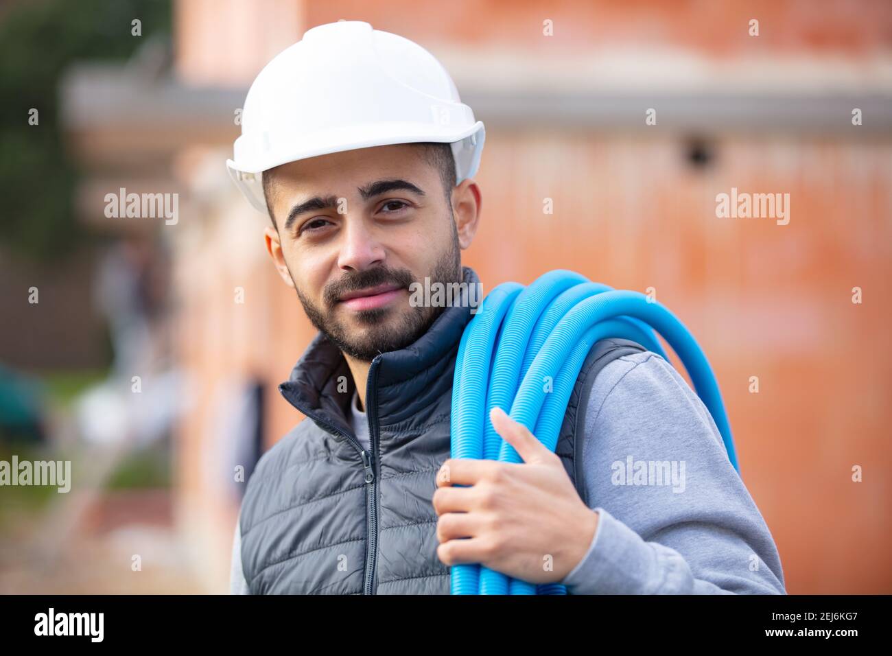 construction worker on site holding pipe Stock Photo - Alamy